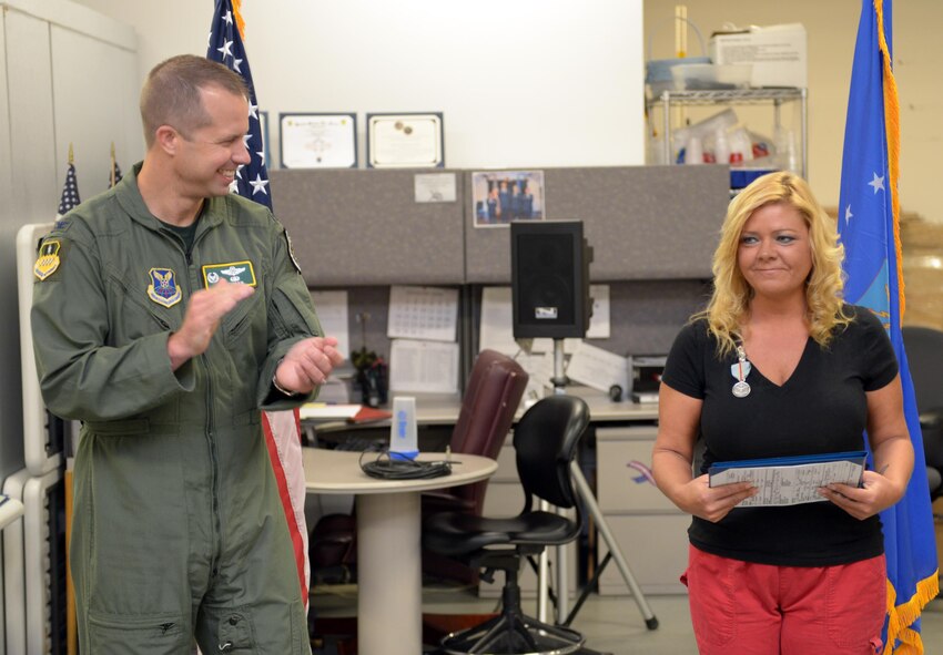 Col. Ty Neuman, 2nd Bomb Wing commander, applauds Kimberly Farmer, 2nd Medical Support Squadron laboratory technician, after recognizing her with the Command Civilian Award for Valor at Barksdale Air Force Base, La., Aug. 12, 2016. Farmer used CPR to save a man’s life while shopping at a convenience store in the local area. (U.S. Air Force photo/Senior Airman Curt Beach)