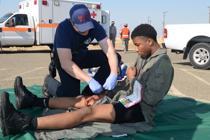 A first responder evaluates a wounded Airman during an active shooter exercise Aug. 17, 2016, at Beale Air Force Base, California. The exercise evaluated Beale first responders actions if an occurrence, such as an active shooter, were to happen on the installation. (U.S. Air Force photo by Senior Airman Ramon A. Adelan) 