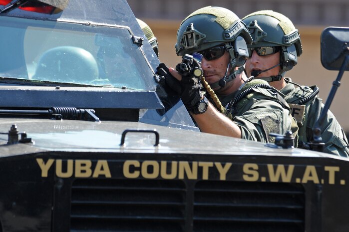A Yuba County Sheriff's Department SWAT member draws his weapon and evaluates the scene of an active shooter exercise Aug. 17, 2016, at Beale Air Force Base, California. Beale personnel and Yuba County SWAT worked cohesively to extract individuals on lockdown and eliminate the simulated threat. (U.S. Air Force photo by Senior Airman Ramon A. Adelan) 