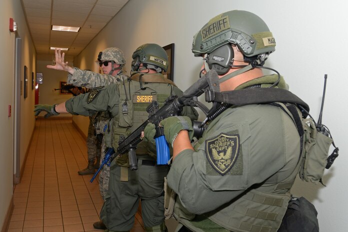 A 9th Security Forces Squadron member briefs a Yuba County Sheriff's Department SWAT member on the current situation of an active shooter exercise Aug. 17, 2016, at Beale Air Force Base, California. Beale personnel and Yuba County SWAT worked cohesively to extract individuals on lockdown and eliminate the simulated threat. (U.S. Air Force photo by Senior Airman Ramon A. Adelan) 
