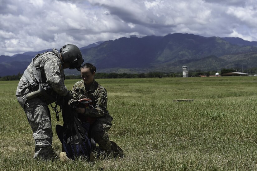 U.S. Army Staff Sgt. Jun Ma, a flight paramedic assigned to the 1st Battalion, 228th Aviation Regiment, helps U.S. Army Spc. Courtney Moreland, a military working dog handler assigned to Joint Task Force-Bravo’s Joint Security Forces, secure herself to her MWD, Puma, during K9 hoist evacuation training at Soto Cano Air Base, Honduras, August 15, 2016. Moreland and Puma were one of three JSF MWD teams to be hoisted, one-by-one, 30 feet into the air.