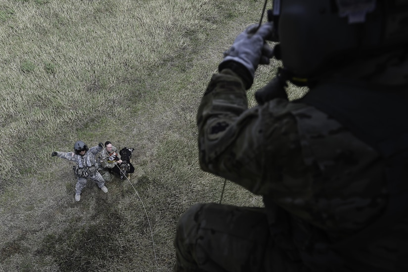 U.S. Army Staff Sgt. Jun Ma, a flight paramedic assigned to the 1st Battalion, 228th Aviation Regiment, signals to U.S. Army Spc. Andrew Briones, 1-228th AVN crew chief, to raise a hoist attached to U.S. Army Spc. Courtney Moreland, a military working dog handler assigned to Joint Task Force-Bravo’s Joint Security Forces, and her MWD, Puma, during training at Soto Cano Air Base, Honduras, August 15, 2016. Although this was the first time for these three particular JSF MWD teams to be hoisted together, the 1-228th AVN regularly conducts hoist operations.