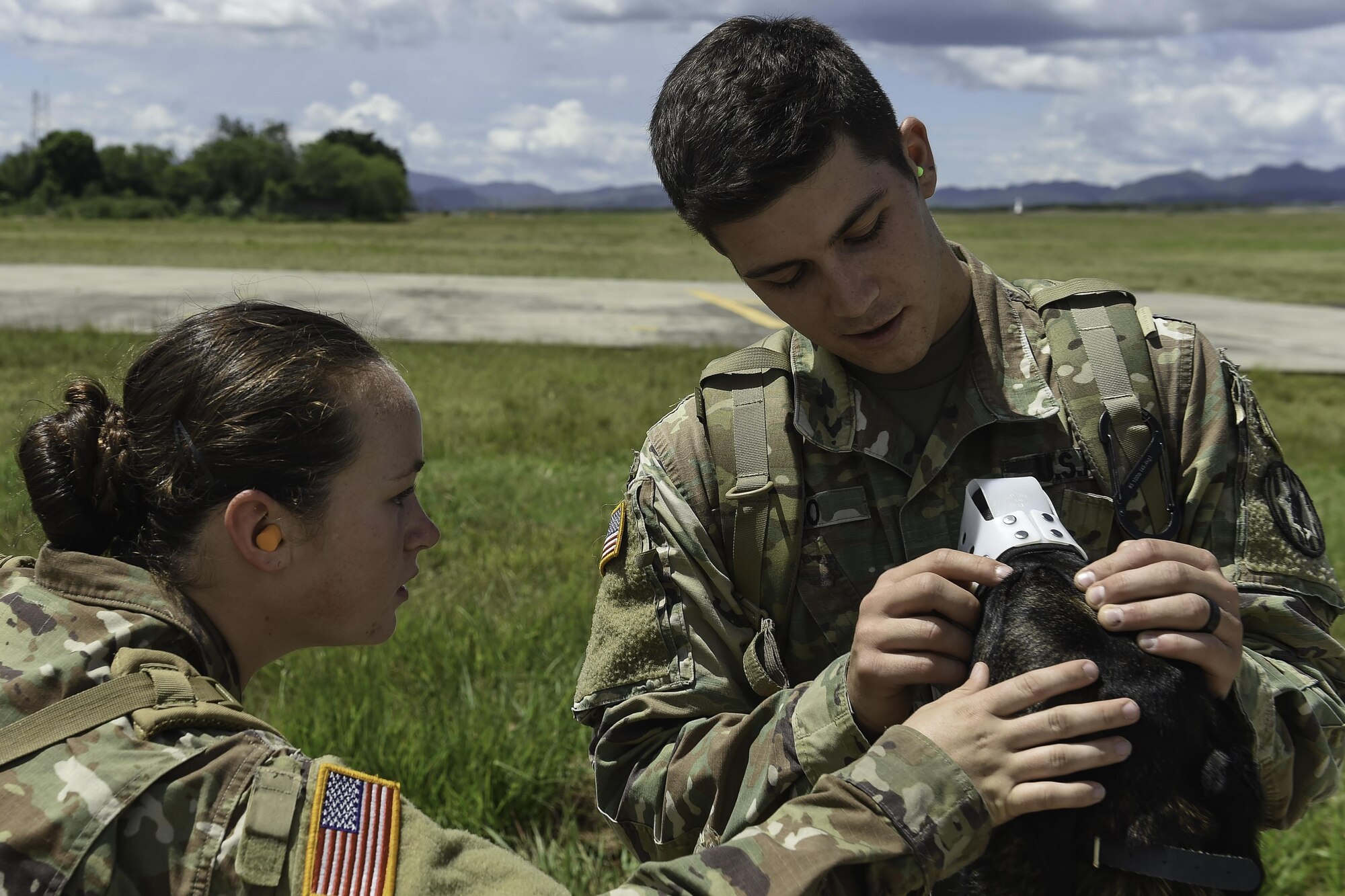 U.S. Army Spcs. Courtney Moreland and Harley Reno, both military working dog handlers assigned to Joint Task Force-Bravo’s Joint Security Forces, look at the face of Reno’s MWD, Kyra, during K9 hoist evacuation training at Soto Cano Air Base, Honduras, August 15, 2016. MWD handlers are responsible for the care and training of their service dog, which contributes to a variety of operations abroad and installation security at home station.