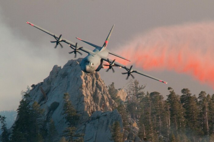 A California Air National Guard Modular Airborne Fire Fighting System-equipped C-130 Hercules aircraft drops fire retardant over Palm Springs Aerial Tramway to fight California wildfires, July 19, 2013. California Air National Guard photo by Staff Sgt. Nick Carzis