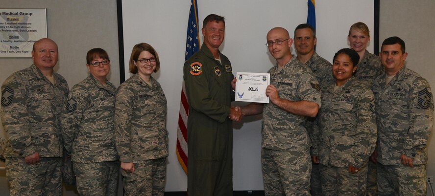 Staff Sgt. Richard McDonald, front right, 47th Medical Support Squadron laboratory NCO in charge, accepts the “XLer of the Week” award from Col. Thomas Shank, front left, 47th Flying Training Wing commander, here, Aug. 10, 2016. The XLer is a weekly award chosen by wing leadership and is presented to those who consistently make outstanding contributions to their unit and Laughlin. (U.S. Air Force photo/Airman 1st Class Brandon May)