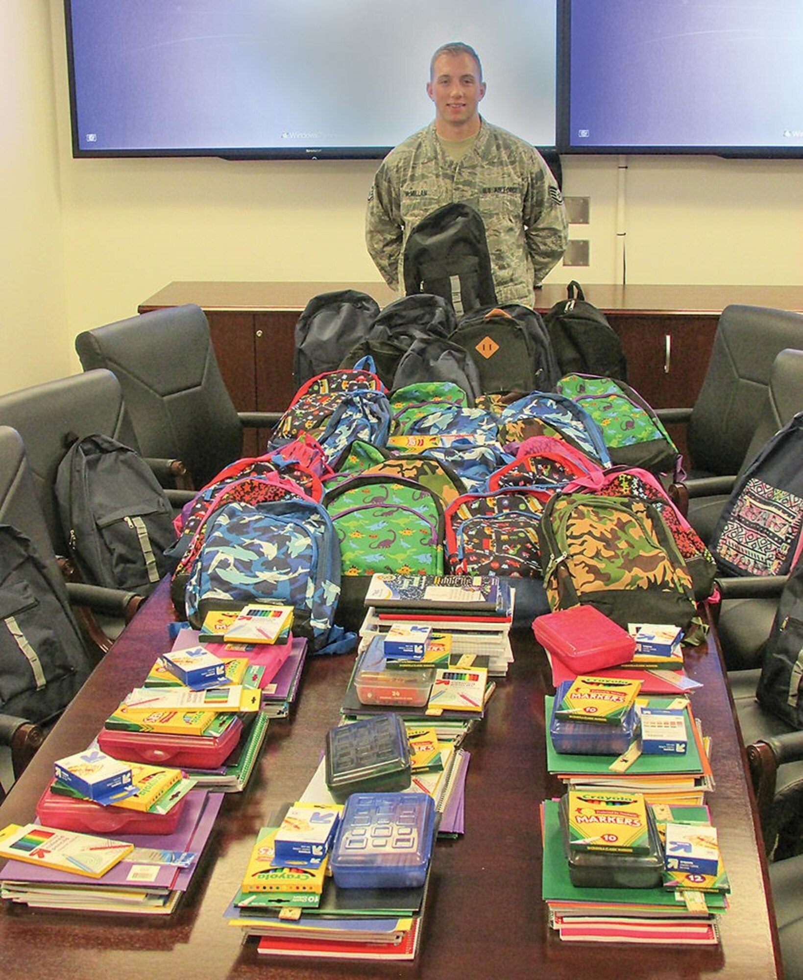 Staff Sgt. Joshua McMillan pauses during sorting out school supplies for "Operation Full Backpack" for a photo. The Nuclear Weapons Center donated to supplies to three elementary schools. (Photo by Argen Duncan)