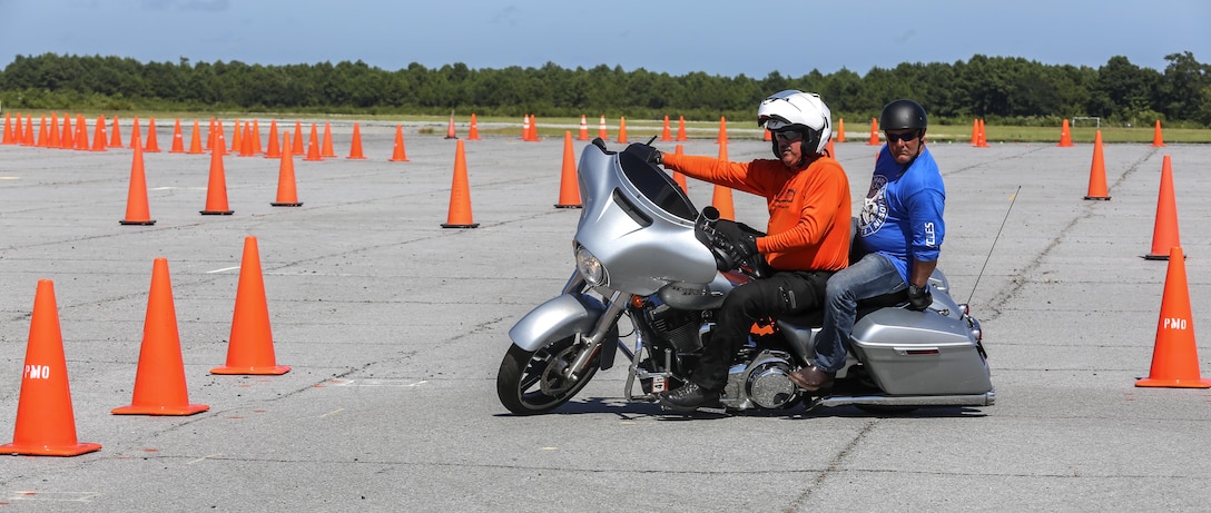 Steve Schuiber, front, a Moto Mark 1 Motorcycle Skill Enhancer instructor, demonstrates to Gunnery Sgt. Chris Foster, a course participant, the precision needed to handle the simulated course in a ‘Bike Safe’ street situational environment at Marine Corps Auxiliary Landing Field Bogue, North Carolina, Aug. 14. Bike Safe is a proactive approach to engage motorcyclist before they do something that’s unsafe. (U.S. Marine Corps photo by Lance Cpl. Tavairus Hernandez /Released)