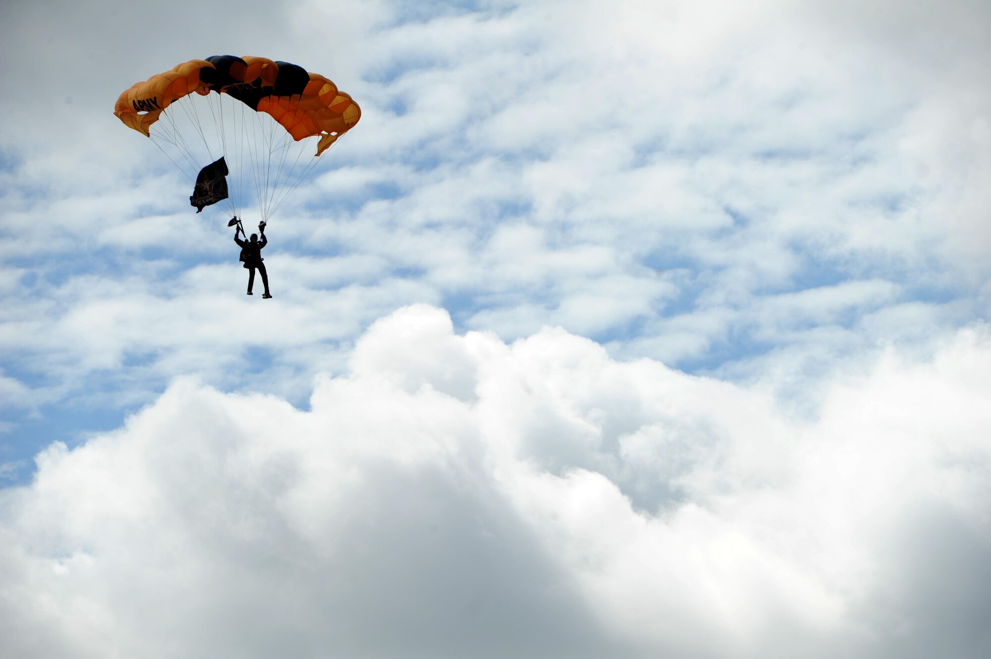 A member from the U.S. Army Golden Knights parachutes over the crowd at the Northern Neighbors Day Air Show at Minot Air Force Base, N.D., Aug. 13, 2016. The Golden Knights were a featured performer at the air show which was the first one for Minot AFB in seven years. (U.S. Air Force photo by Staff Sgt. Chad Trujillo)