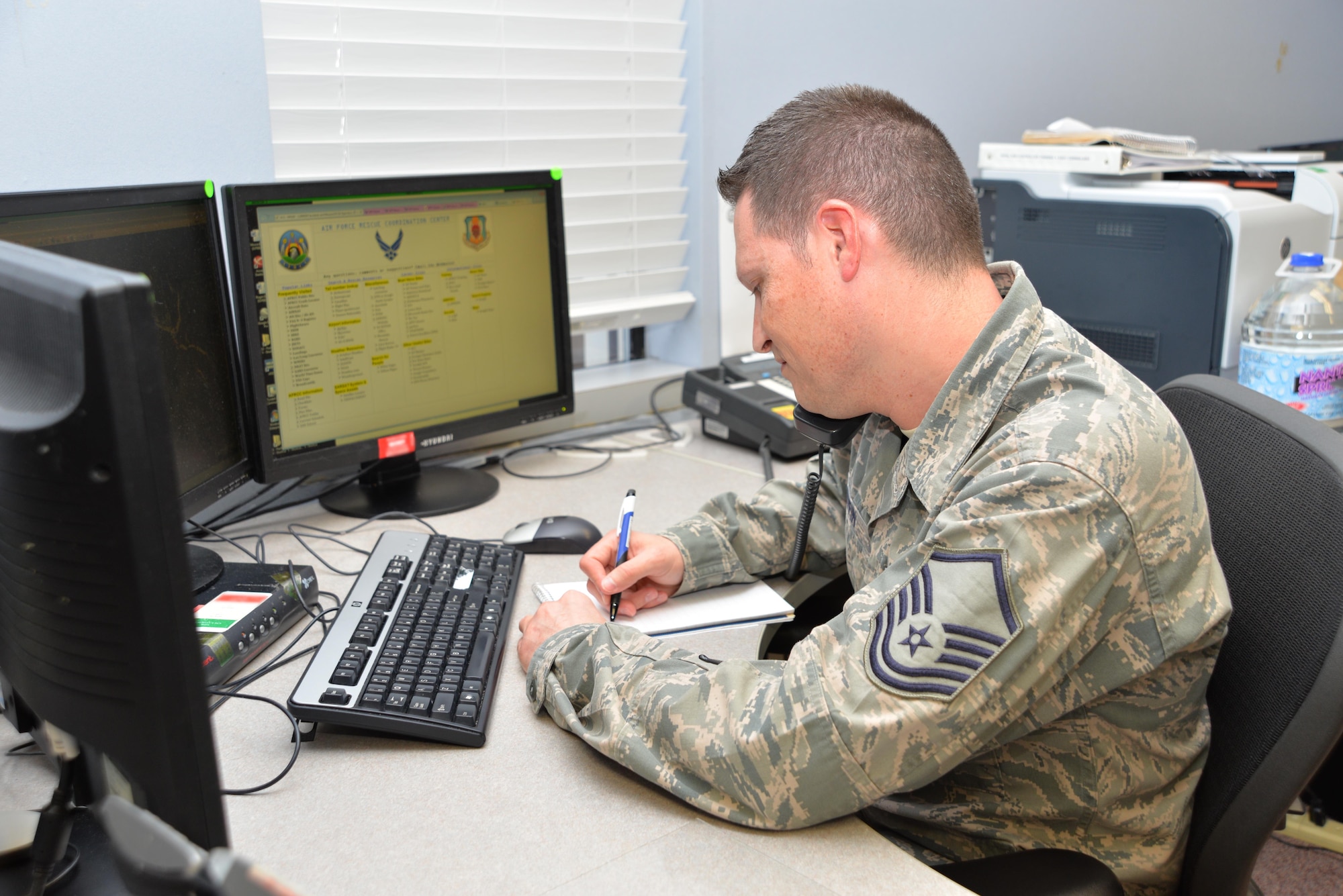 U.S. Air Force Master Sgt. Peter Griffin, Air Force Rescue Coordination Center superintendent, answers  the phone on the AFRCC Operations Floor at Tyndall Air Force Base, Fla., Aug. 18, 2016. Griffin worked the AFRCC mission marking the 200th save for the unit in 2016 on Aug. 17, 2016. The AFRCC operates 24 hours a day, seven days a week, and serves as the single agency responsible for coordinating on-land federal search and rescue activities in the 48 contiguous United States, Mexico, and Canada. (Photo by Maj. Andrew Scott)