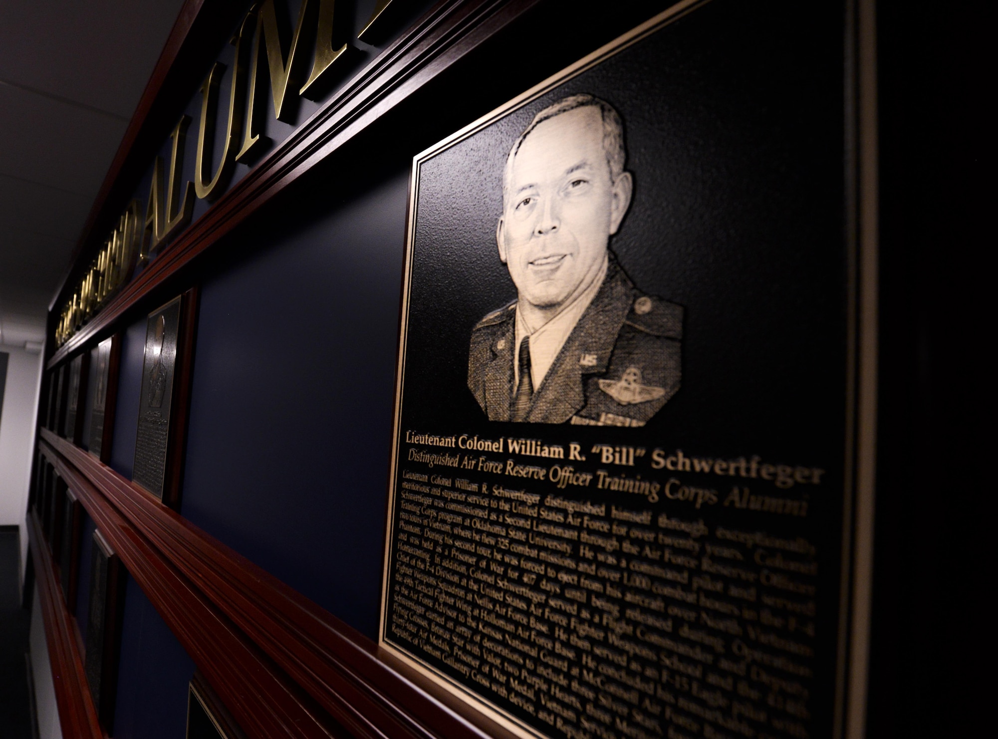 An engraved photo of retired Lt. Col. William Schwertfeger, 2016 Holm Center Distinguished Alumni inductee, hangs on display besides the previous honorees on the Distinguished Alumni wall inside the Air Force Reserve Officer Training Corps Headquarters, August 18, 2006, Maxwell Air Force Base, Ala. The Distinguished Alumni program honors graduates who achieved a high level of success during or after their service in the Air Force. (U.S. Air Force photo/ SrA Alexa Culbert) 