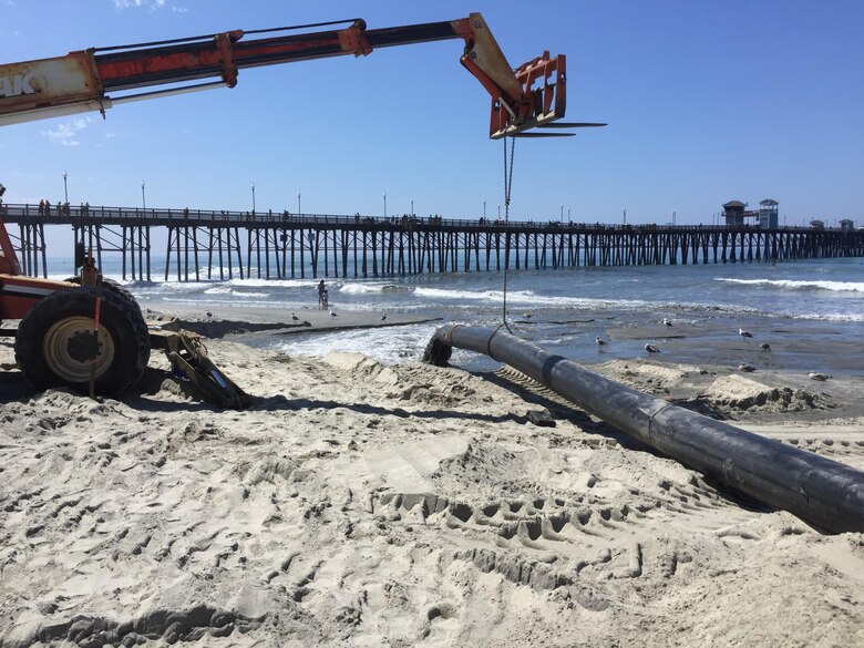 Material from the navigational dredging project at Oceanside Harbor discharges on the beach adjacent to the Oceanside Pier. Through mid-August, the contractor has placed about 126,700 cubic yards of material on the beach, resulting in more recreational area for beachgoers and increased protection for residents and business adjacent to the coast.