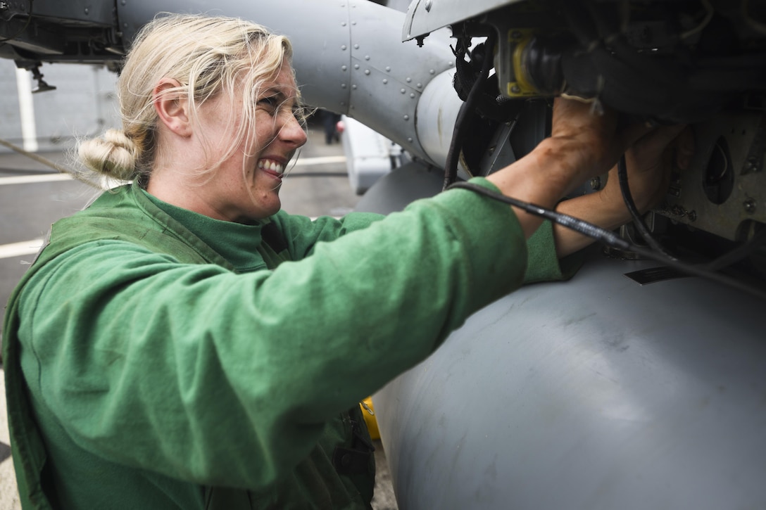 Navy Petty Officer 3rd Class Kaylyn Breast performs preflight maintenance on an MH-60R Seahawk helicopter on the flight deck of the USS Shoup in the Pacific Ocean, Aug. 16, 2016. The Shoup is conducting routine operations in the Pacific Ocean. Navy photo by Petty Officer 2nd Class Holly L. Herline