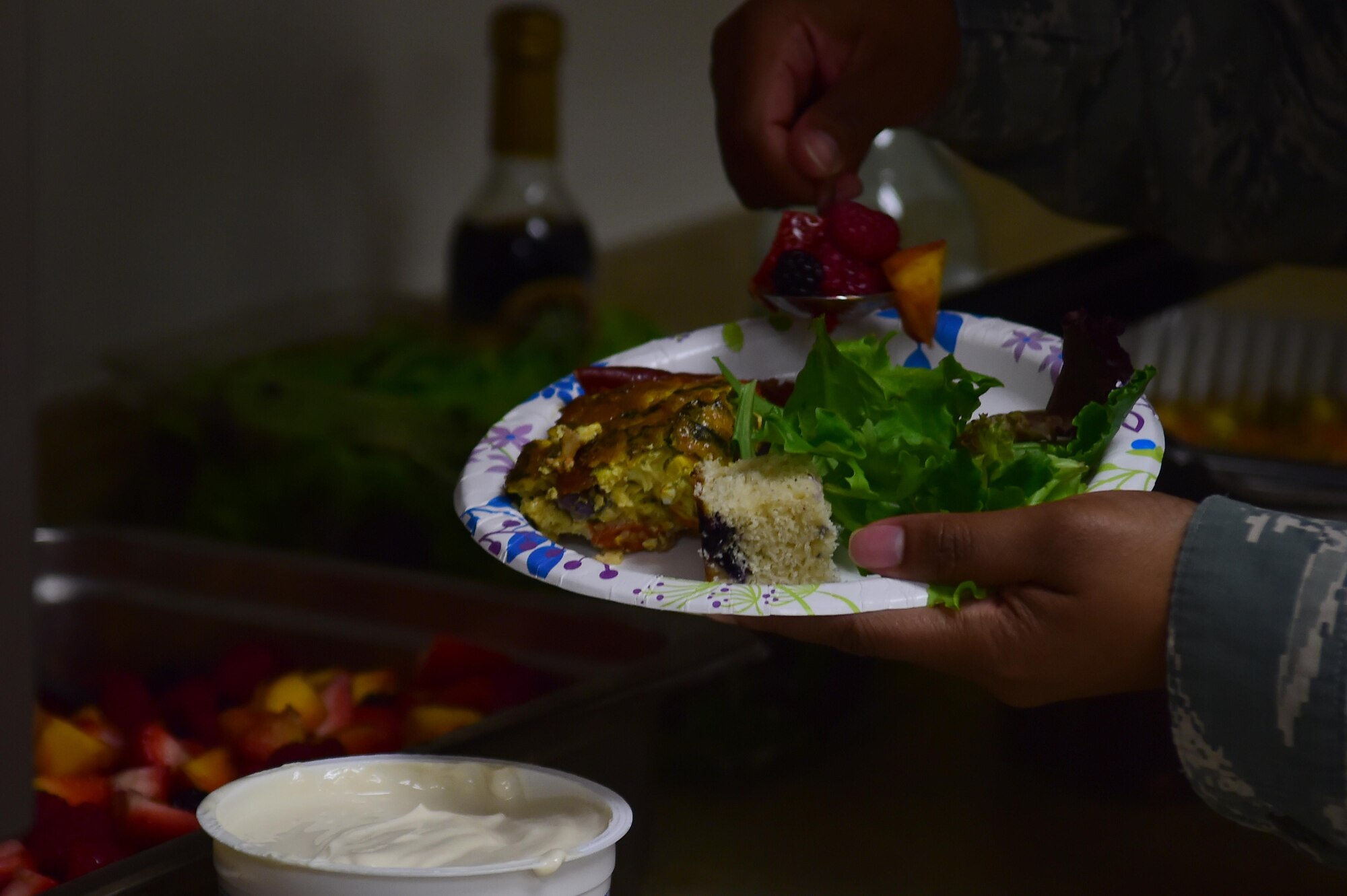 A Team Buckley member fills her plate with various foods August 18, 2016, at the Health and Wellness Center on Buckley Air Force Base, Colo. Charlotte Muller, Whole Foods chef, put on a cooking demonstration that taught audience members how to cook healthy and expand the ingredients they use. (U.S. Air Force photo by Senior Airman Luke W. Nowakowski/Released)