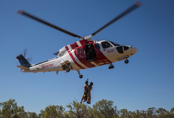 Marine Fighter Attack Squadron (VMFA) 122 U.S. Navy Lt. Matthew Case, flight surgeon, and U.S. Navy Petty Officer 3rd Class Juan Garcia, hospital corpsman, are hoisted into a Sikorsky S76A++ Search and Rescue helicopter while conducting SAR training during Exercise Pitch Black 2016 at Royal Australian Air Force Base Tindal, Australia, Aug. 16, 2016.  The SAR team trains with local and international forces during exercises like Pitch Black to ensure all medical personnel that can respond to an aircraft emergency are capable of carrying out the same procedures. The biennial, multinational exercise involves approximately 10 allied nations and prepares these forces for possible real-world scenarios. The bilateral effort amongst Exercise Pitch Black 2016 furthermore showcases the strength amongst various militaries and solidifies the relationship across the Pacific region. (U.S. Marine Corps photo by Cpl. Nicole Zurbrugg)