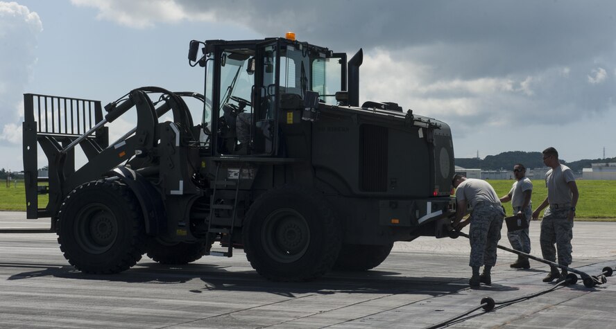 Airmen from the 18th Civil Engineer Squadron prepare for aircraft barrier training Aug. 16, 2016, at Kadena Air Base, Japan. The 18th CES conducted aircraft barrier training to ensure preparedness in the event of an in-flight emergency. The aircraft barrier is designed to catch an aircraft as it lands on the flightline.  (U.S. Air Force photo by Airman 1st Class Lynette M. Rolen)