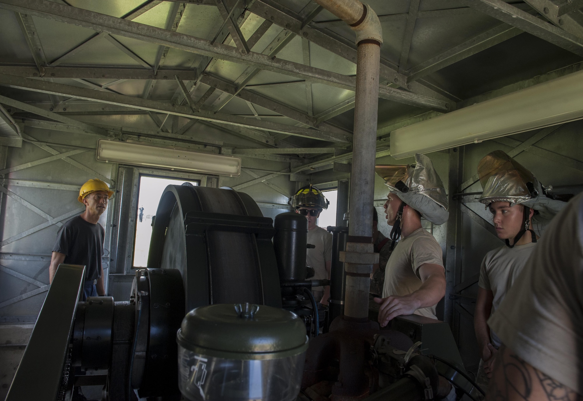 Airmen from the 18th Civil Engineer Squadron prepare to reel in a cable inside an aircraft barrier shack Aug. 16, 2016, at Kadena Air Base, Japan. During a training scenario, Airmen from the 18th CES simulated an aircraft landing on an aircraft barrier. After the aircraft was secured, the cable used to catch the aircraft needed to be pulled back into position to be used again. (U.S. Air Force photo by Airman 1st Class Lynette M. Rolen)