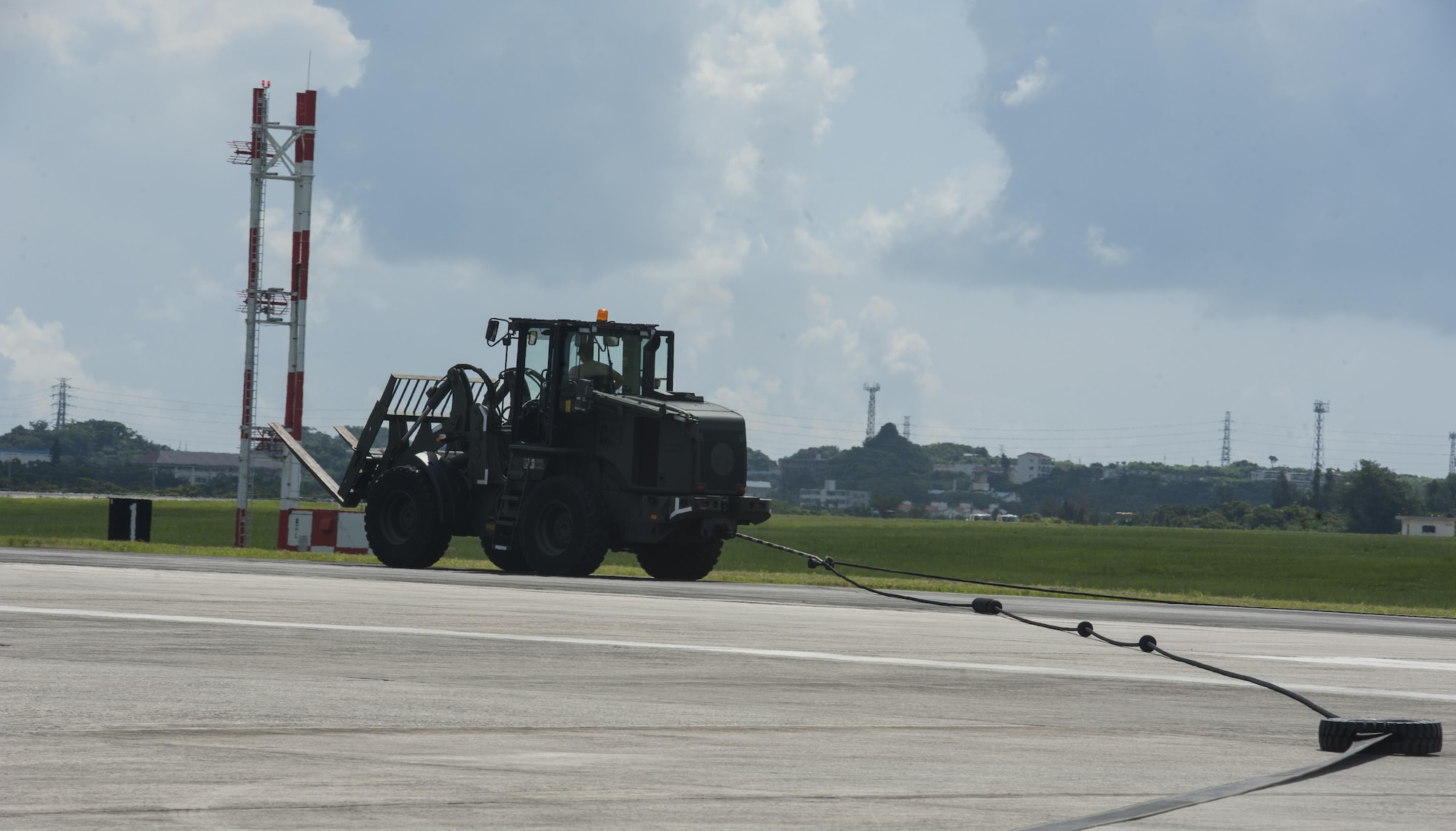 Staff Sgt. Fardad Alimehri, 18th Civil Engineer Squadron electrical power production and barrier maintenance technician, simulates an aircraft landing on an aircraft barrier Aug. 16, 2016, at Kadena Air Base, Japan. The aircraft barrier catches an aircraft as it makes its landing, ensuring security for the aircraft and pilot. (U.S. Air Force photo by Airman 1st Class Lynette M. Rolen)