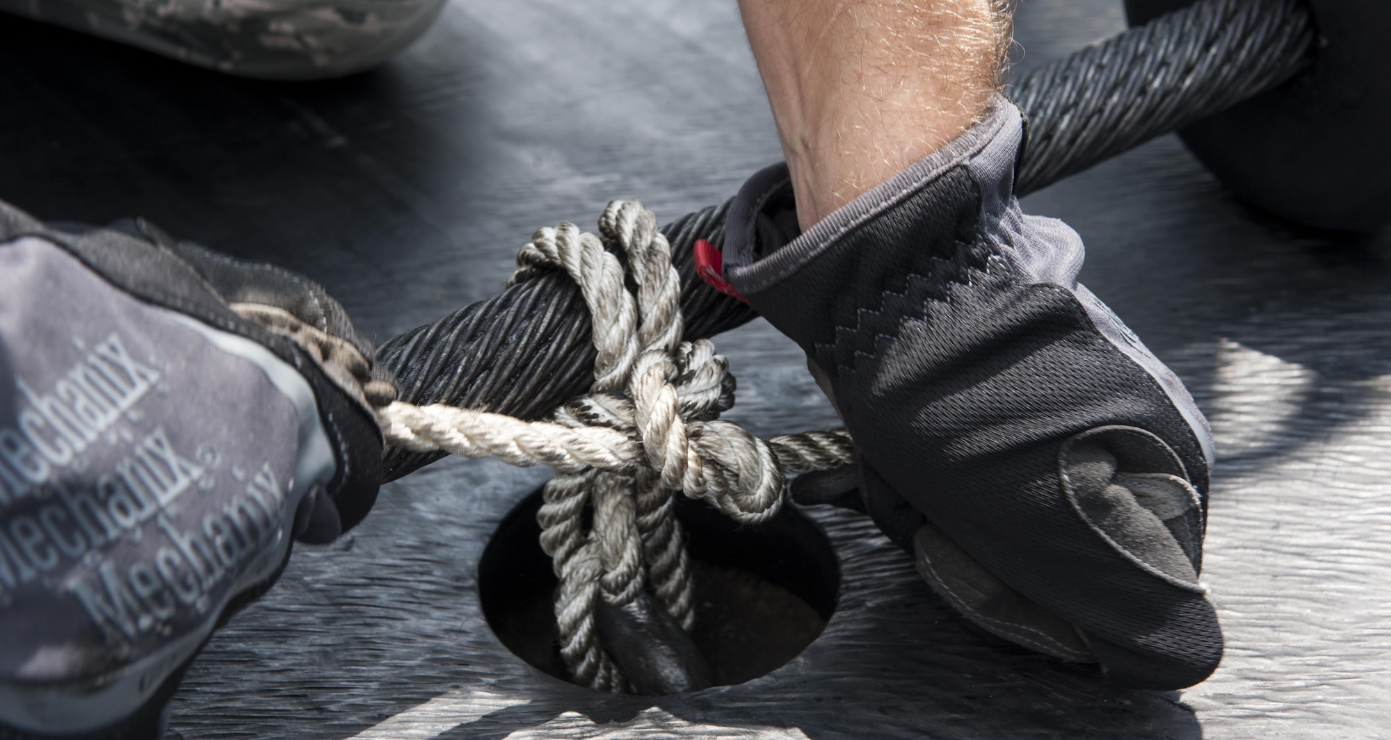 An aircraft barrier cable is secured by Airman 1st Class Hayden Skidmore, 18th Civil Engineer Squadron firefighter, Aug. 16, 2016, at Kadena Air Base, Japan. Airmen were taught proper methods for securing the cable to ensure preparedness for an in-flight emergency, in the event of one. (U.S. Air Force photo by Airman 1st Class Lynette M. Rolen)