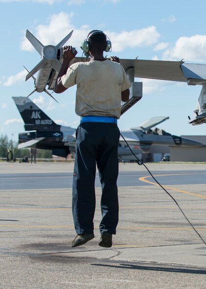 U.S. Air Force Senior Airman Christopher Tidline, a 354th Maintenance Squadron aircrew egress technician who is cross-utilized in a crew chief’s role for the 354th Aircraft Maintenance Squadron, jumps to inspect the top of an F-16 Fighting Falcon aircraft wing while preparing the jet for a sortie Aug. 17, 2016, during RED FLAG-Alaska (RF-A) 16-3 at Eielson Air Force Base, Alaska. RF-A enables joint and international maintenance units to sharpen their skills by preparing jets to fly simulated combat sorties in a realistic threat environment. (U.S. Air Force photo by Staff Sgt. Shawn Nickel)
