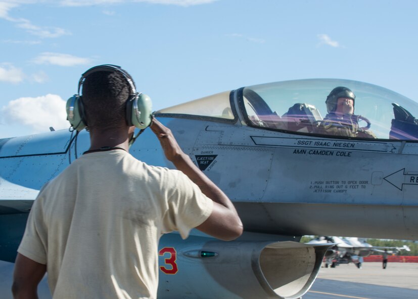 U.S. Air Force Senior Airman Christopher Tidline, a 354th Maintenance Squadron aircrew egress technician who is cross-utilized as a crew chief for the 354th Aircraft Maintenance Squadron, salutes Royal Canadian Air Force Capt. Michael Walker, an 18th Aggressor Squadron pilot, as he leaves for a sortie Aug. 17, 2016, during RED FLAG-Alaska 16-3 at Eielson Air Force Base, Alaska. This exercise provides unique opportunities to integrate various forces into joint, coalition and multilateral training from simulated forward operating bases. (U.S. Air Force photo by Staff Sgt. Shawn Nickel)