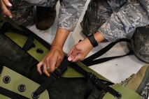 U.S. Air Force Staff Sgt. Krystal Champ, a 354th Medical Operation Squadron unit training manager, secures a simulated casualty during training Aug. 12, 2016, in Hangar 6 at Ladd Army Airfield on Fort Wainwright, Alaska. The casualty must be properly secured otherwise they could suffer additional injuries. (U.S. Air Force photo by Airman Isaac Johnson)
