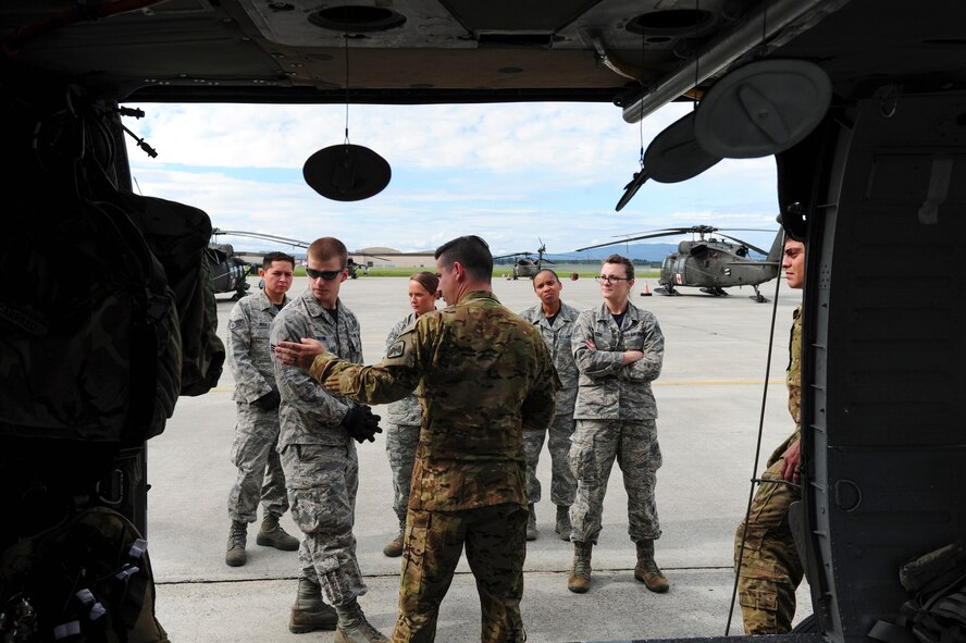 U.S. Airmen assigned to the 354th Medical Operations Squadron at Eielson Air Force Base, Alaska, receive instructions on transporting a casualty to a helicopter during joint training Aug. 12, 2016, outside Hangar 6 on Ladd Army Airfield at Fort Wainwright, Alaska. This portion of the training was conducted with U.S. Army UH-60 Black Hawk helicopter and it medevac crew. (U.S. Air Force photo by Airman Isaac Johnson)
