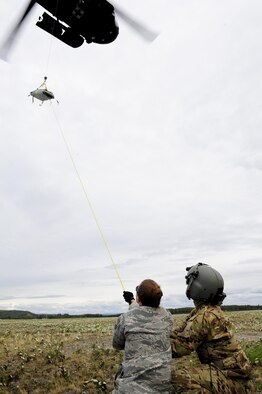 U.S. Air Force Senior Airman Roxanne Lawrence, a 354th Medical Operations Squadron nurse technician, at Eielson Air Force Base, Alaska, helps stabilize a simulated casualty while it is lifted up to a U.S. Army UH-60 Black Hawk helicopter during medical evacuation training Aug. 12, 2016, outside Hangar 6 at Ladd Army Airfield on Fort Wainwright, Alaska. The simulated causality had to travel 60 feet up to the helicopter during this part of the training. (U.S. Air Force photo by Airman Isaac Johnson)