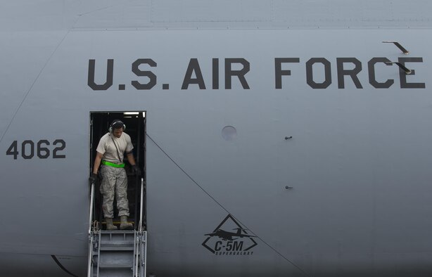 Staff Sgt. Eric Booker, 621st Contingency Response Squadron crew chief, steps out from a C-5M Super Galaxy at Yokota Air Base, Japan, Aug. 16, 2016. The 621 CRS sent 12 aircraft maintainers to Yokota to gain proficiency and training on a variety of aircraft used in contingency operations. (U.S. Air Force photo by Yasuo Osakabe/Released) 