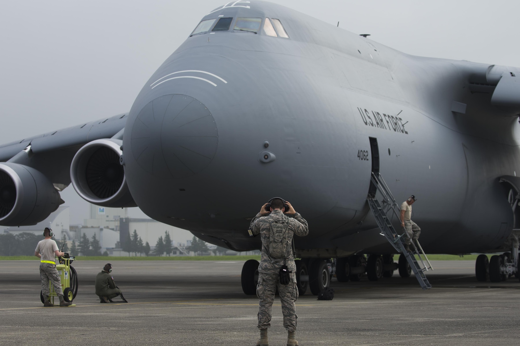 Members with the 621st Contingency Response Squadron conduct preflight checks on a C-5M Super Galaxy at Yokota Air Base, Japan, Aug. 16, 2016. The 621 CRS sent crew chief to Yokota to gain proficiency and training on a range of aircraft, working alongside the 730th Air Mobility Squadron. The 730 AMS often works with C-5, C-17A Globemaster III, KC-135 Stratotanker, KC-10A Extender and civilian aircraft. (U.S. Air Force photo by Yasuo Osakabe/Released)