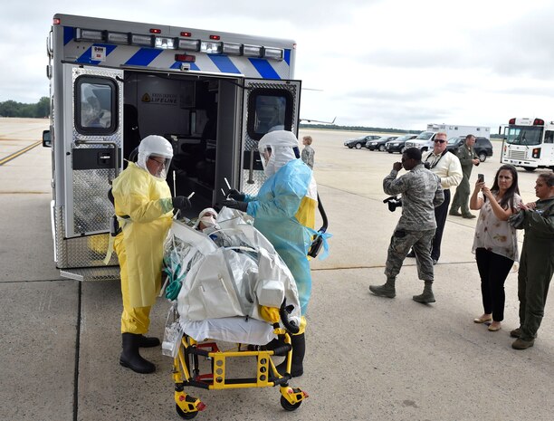 Paramedics from Walter Reed National Military Medical Center load Major Stephanie La Pierre, the patient simulating a potential exposure to Ebola and individual mobilization augmentee to the Air Mobility Command surgeon general command surgeon's office medical readiness division, into an ambulance for Exercise Mobility Solace at Joint Base Andrews, Md., Aug. 16, 2016. Mobility Solace provides Air Mobility Command, working with joint partners, the opportunity to evaluate the protocols and operational sequences of moving multiple patients exposed or infected with Ebola using the TIS, while also minimizing the risks to aircrew, medical attendants and the airframe. The TIS is a modular, scalable system, composed of at least one isolation pallet for patient transportation and care, one pallet configured as an antechamber to provide medical members with an enclosed space to safely decontaminate and remove their personal protective equipment before exiting. (U.S. Air Force Photo/Airman Megan Munoz)
