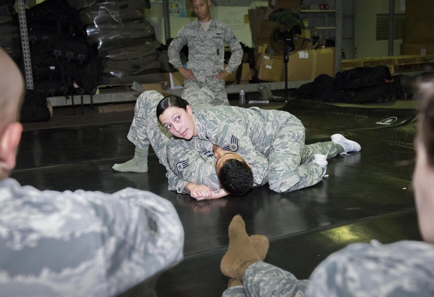 Staff Sgt. Kiirstyn Gunterman, 374th Security Forces Squadron assistant NCO in charge of training, instructs Security Forces personnel on combatives techniques at Yokota Air Base, Japan, Aug. 16 2016. The Air Force requires all security forces personnel to know how to use martial arts techniques properly as effective and non-deadly defensive techniques. (U.S. Air Force photo by Airman 1st Class Baker/Released)