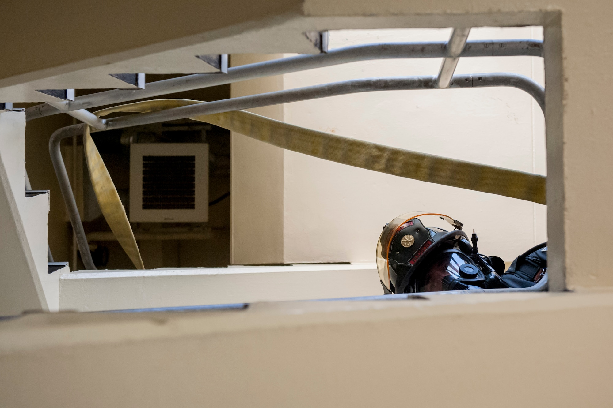 Senior Airman Brandon Hudson, 18th Civil Engineer Squadron firefighter, looks down a stairwell during a tower evacuation drill Aug. 15, 2016, at Kadena Air Base, Japan. Hudson and other firefighters of the 18th CES conduct fire and rescue exercises twice per week in order to remain ready day and night for possible emergencies. (U.S. Air Force photo by Senior Airman Peter Reft)