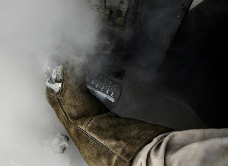 Senior Airman Donte Hatcher, 379th Expeditionary Logistics Readiness Squadron fuels cryogenic operator, takes a sample from a liquid oxygen tank to ensure its safety during an inspection Aug. 5, 2016, at Al Udeid Air Base, Qatar. Taking a sample of the liquid oxygen is one way Hatcher ensures the product is 99.5 percent pure or higher, which allows aircrew to accomplish their missions safely. (U.S. Air Force photo/Senior Airman Janelle Patiño/Released)