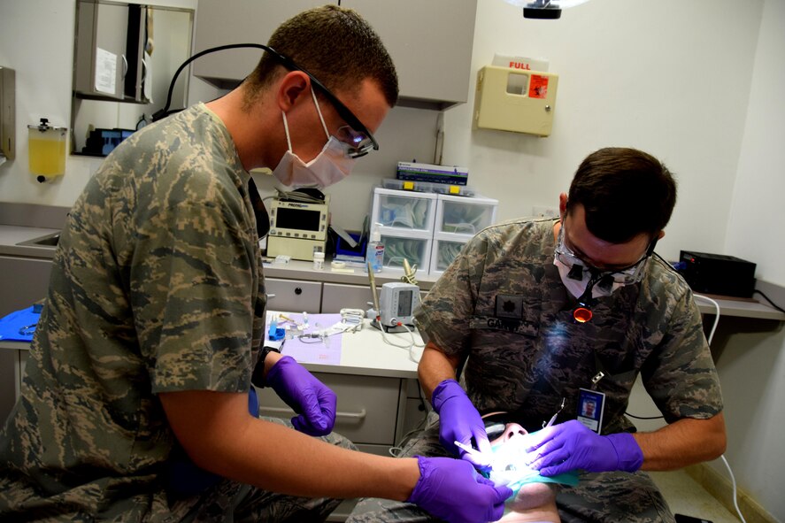 Dr. (Maj.) Benjamin Gantt, 379th Expeditionary Medical Operations Squadron dentist, adjusts a handheld mirror during a root canal procedure on Senior Airman Jordan Thompson, 379th Expeditionary Logistics Readiness Squadron fuels and cryogenics operator, July 30, 2016, at Al Udeid Air Base, Qatar. The dental clinic treats all service members and coalition partners stationed here and at Camp As Sayliyah, to include permanent party members and their families assigned here through the Command Sponsorship Program. (U.S. Air Force photo/Technical Sgt. Carlos J. Treviño/Released)
