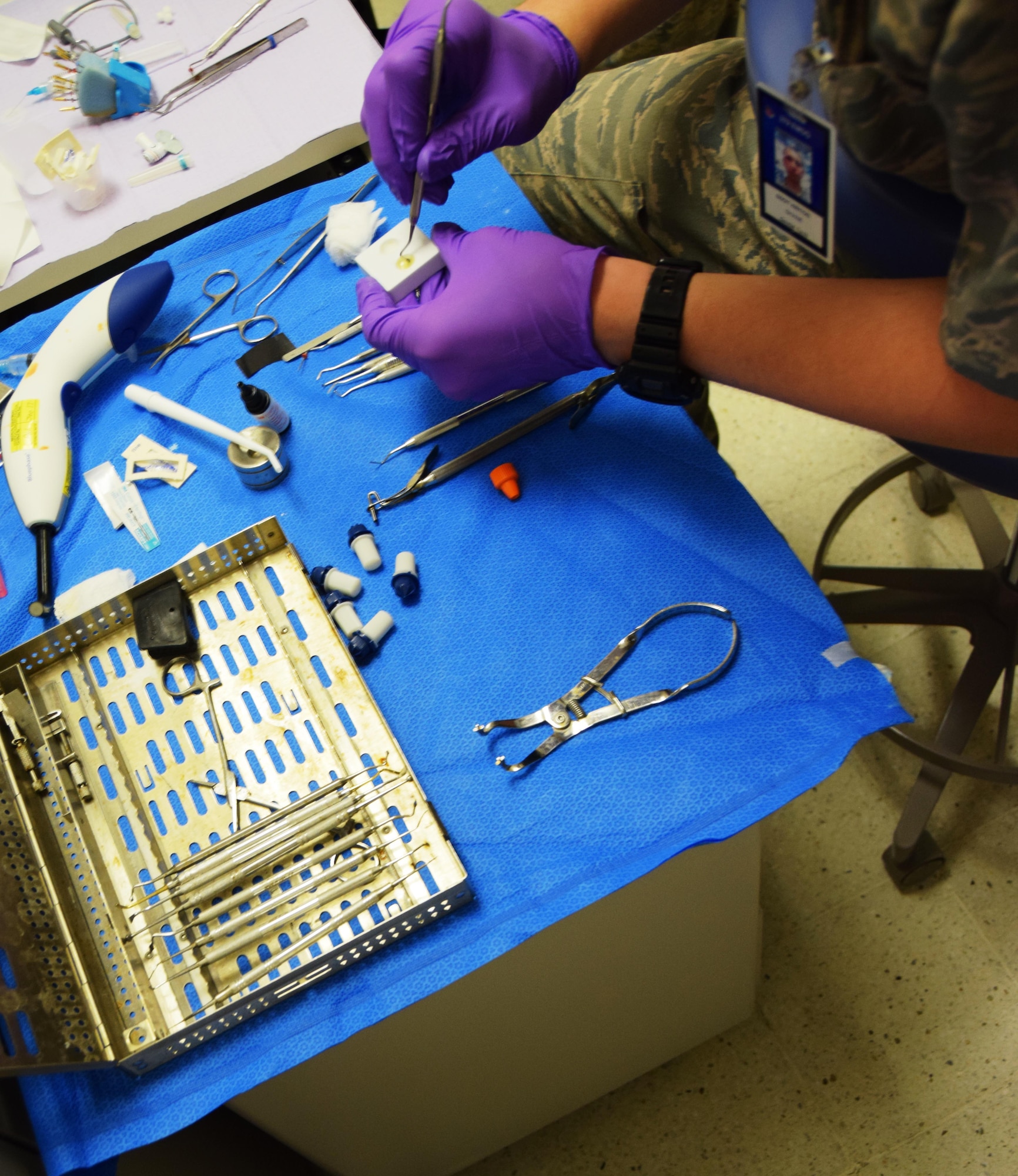 Sgt. Shane Hinton, 379th Expeditionary Medical Group dental technician, uses a dental probe to mix ingredieants for a a root canal on Senior Airman Jordan Thompson, 379th Expeditionary Logistics Readiness Squadron, July 30, 2016, Al Udeid Air Base, Qatar. Hinton was assisting Maj. (Dr.) Benjamin Gantt, a dentist  with the 379th Expeditionary Medical Group Dental Clinic, in treating Thompson. The clinic is an important component of the mission here, having to go to the dentist leads to other Airmen having to cover for someone seeking treatment. (U.S. Air Force photo/Technical Sgt. Carlos J. Treviño/Release)