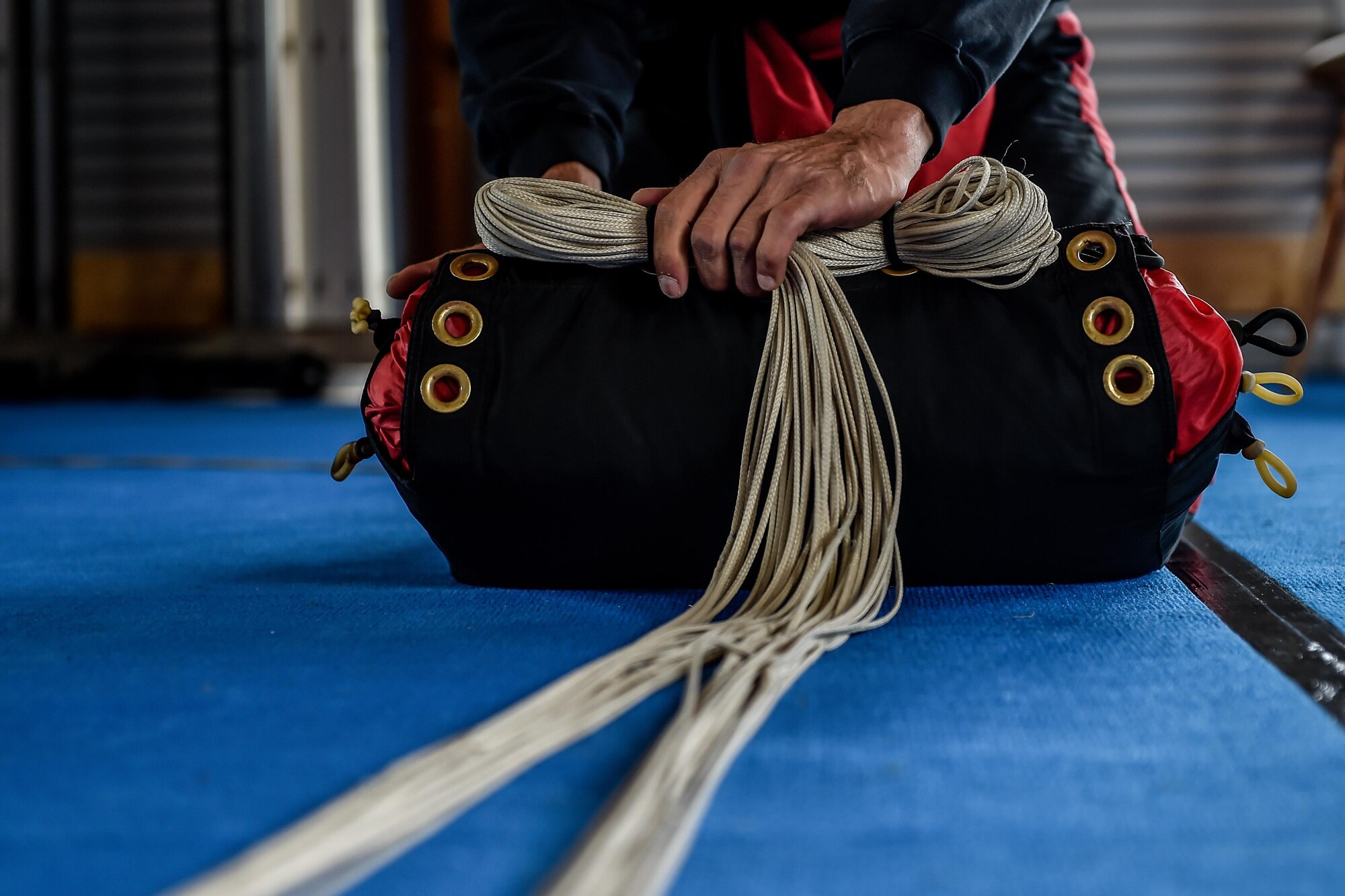 A skydiver packs a parachute before a tandem jump in Wallerfangen, Germany, Aug. 13, 2016. Fifteen Airmen from Ramstein received the opportunity to take a ‘leap of faith’ during a skydiving trip to build upon the pillars of RUfit. (U.S. Air Force photo/Senior Airman Nicole Keim)