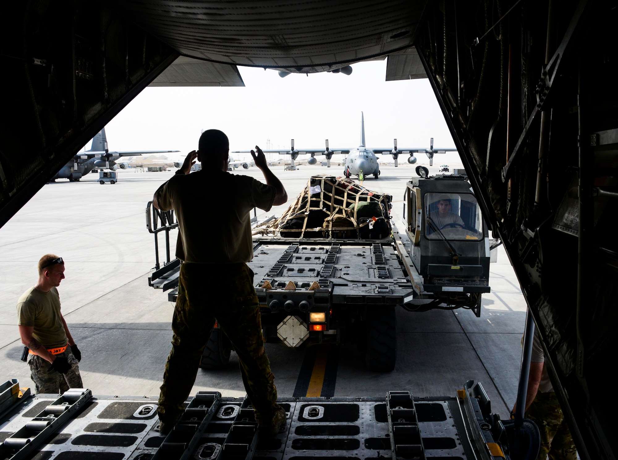 Master Sgt. Maurice Shivers, 746th Expeditionary Airlift Squadron loadmaster, marshals a K-Loader vehicle in preparation of loading equipment into a C-130 Hercules June 28, 2016, at Al Udeid Air Base, Qatar. A total of 147 Airmen from the 914th Airlift Wing out of Niagara Falls Air Reserve Station, N.Y., are deployed here under the 746h EAS and 746th Expeditionary Aircraft Maintenance Unit to execute C-130 combat missions in support of Operation Inherent Resolve and Operation Freedom’s Sentinel. (U.S. Air Force photo/Senior Airman Janelle Patiño/Released)
