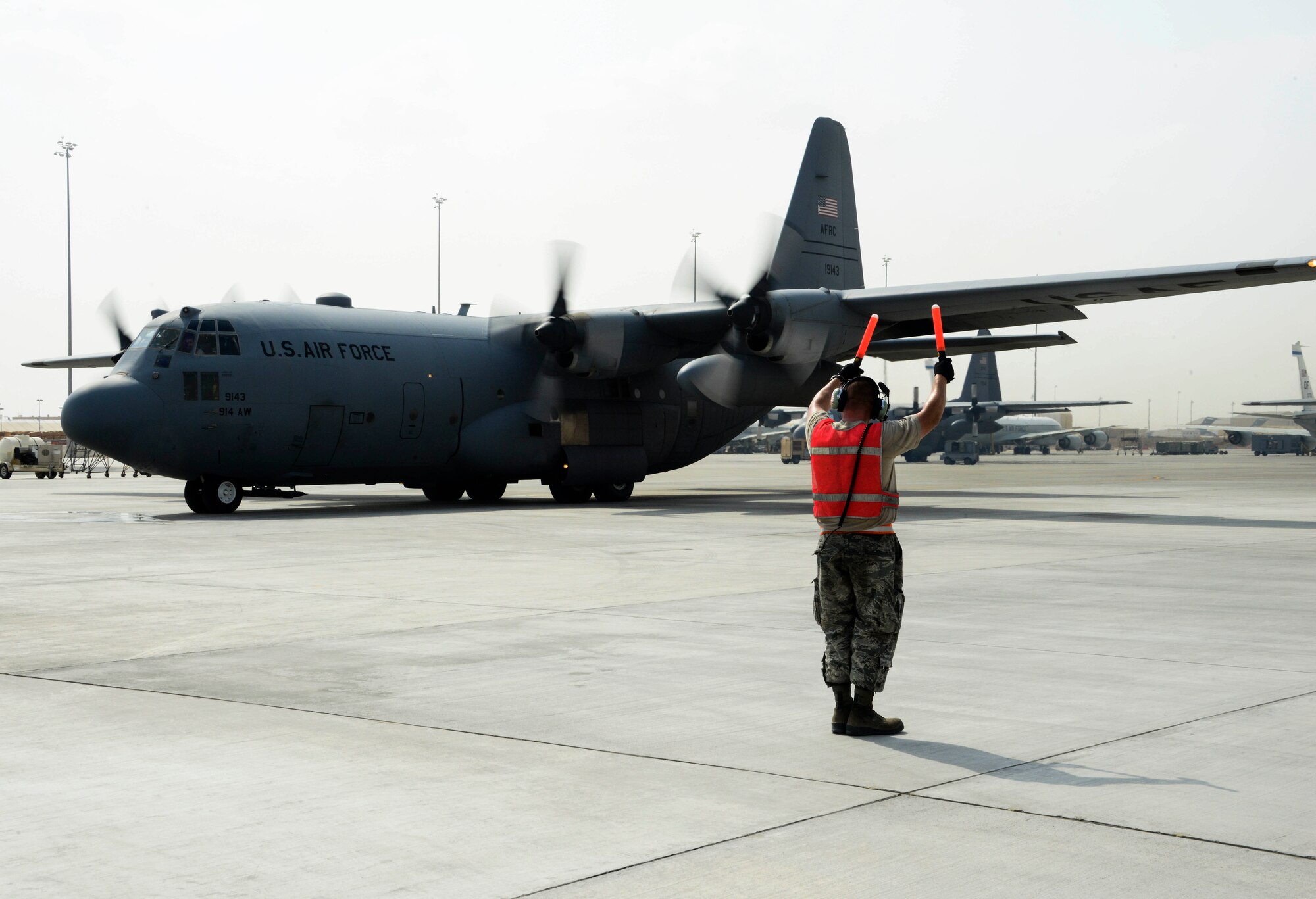 Senior Airman Steven Engels, 379th Expeditionary Aircraft Maintenance Squadron crew chief, marshals a C-130 Hercules on the flight line June 28, 2016, at Al Udeid Air Base, Qatar. Airmen from the 379th EAMXS are responsible for ensuring the aircraft are maintained to exact standards to support Operation Inherent Resolve and Operations Freedom’s Sentinel. (U.S. Air Force photo/Senior Airman Janelle Patiño/Released)