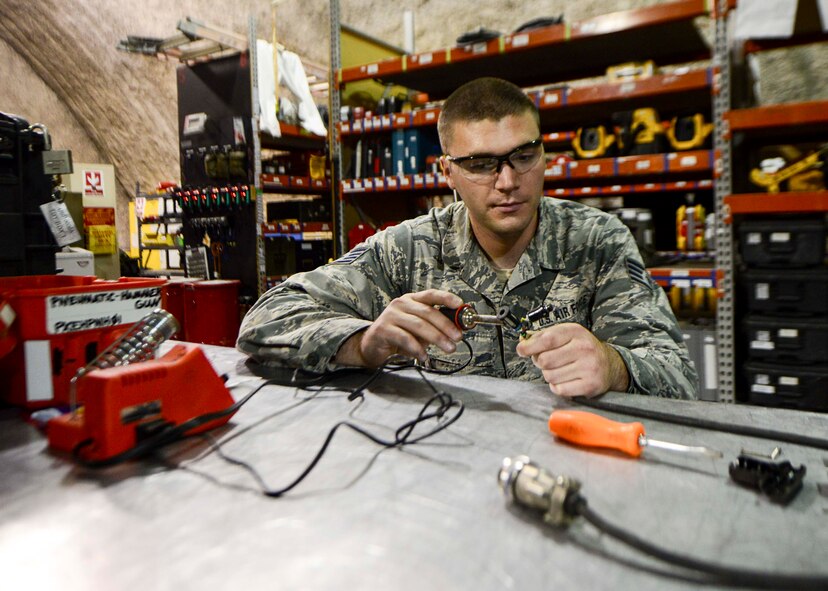 Staff Sgt. Taylor Elia, 379th Expeditionary Aircraft Maintenance Squadron communication navigation mission systems specialist, fixes a communication cord at the repair reference shop Aug. 12, 2016, at Al Udeid Air Base, Qatar. Airmen from the 379th EAMXS are responsible for ensuring the aircraft are maintained to exact standards to support Operation Inherent Resolve and Operations Freedom’s Sentinel. (U.S. Air Force photo/Senior Airman Janelle Patiño/Released)