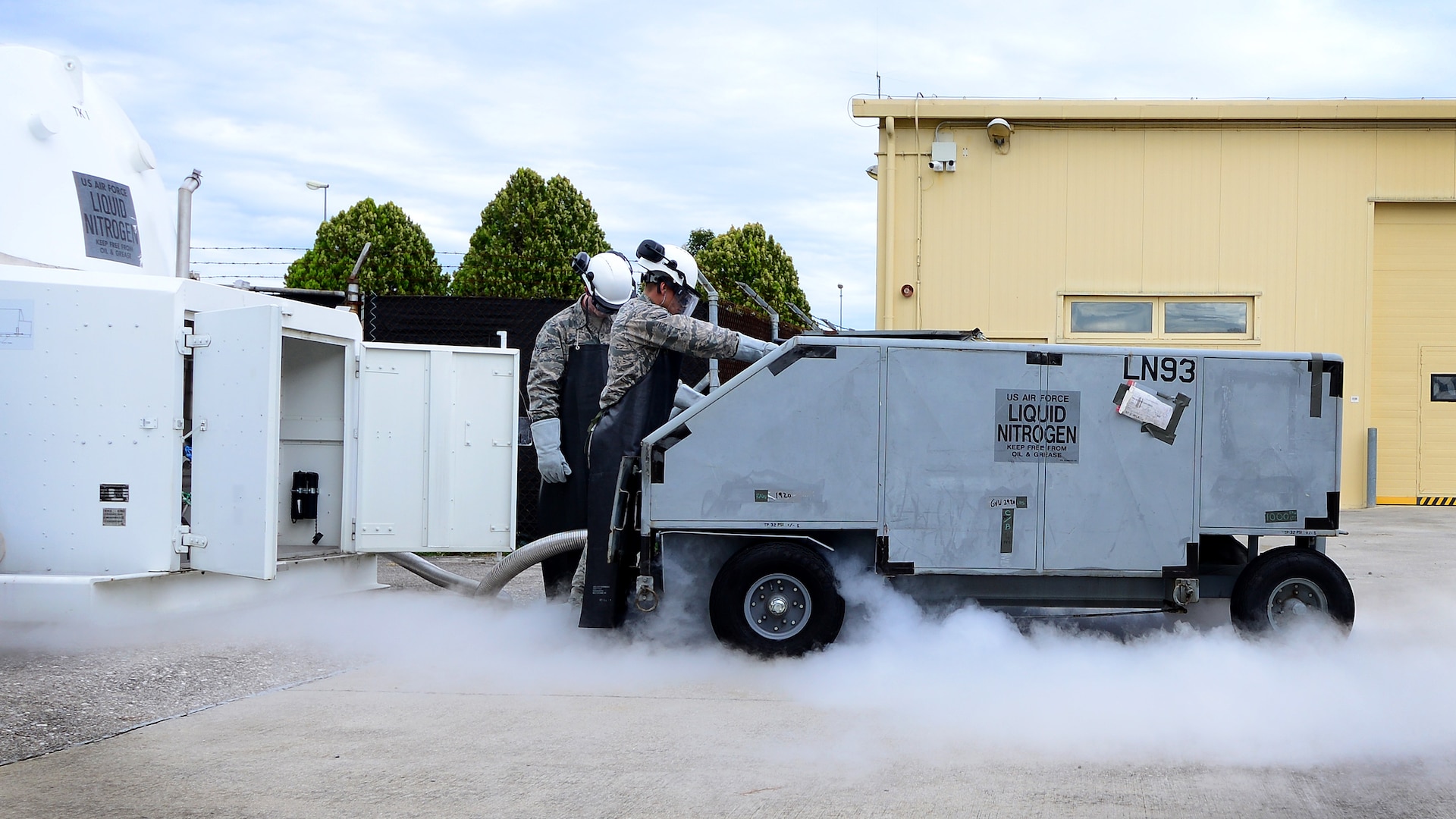 (From left) Airman 1st Class Aaron Debolt and Staff Sgt. Chantz Wyant, 31st Logistics Readiness Squadron fuels facility personnel, fill a liquid nitrogen cart, Aug. 10, 2016, at Aviano Air Base, Italy. Cryogenics Airmen fill an average of 1,200 gallons of liquid oxygen and 1,200 gallons of liquid nitrogen monthly. (U.S. Air Force photo by Senior Airman Areca T. Bell/Released)