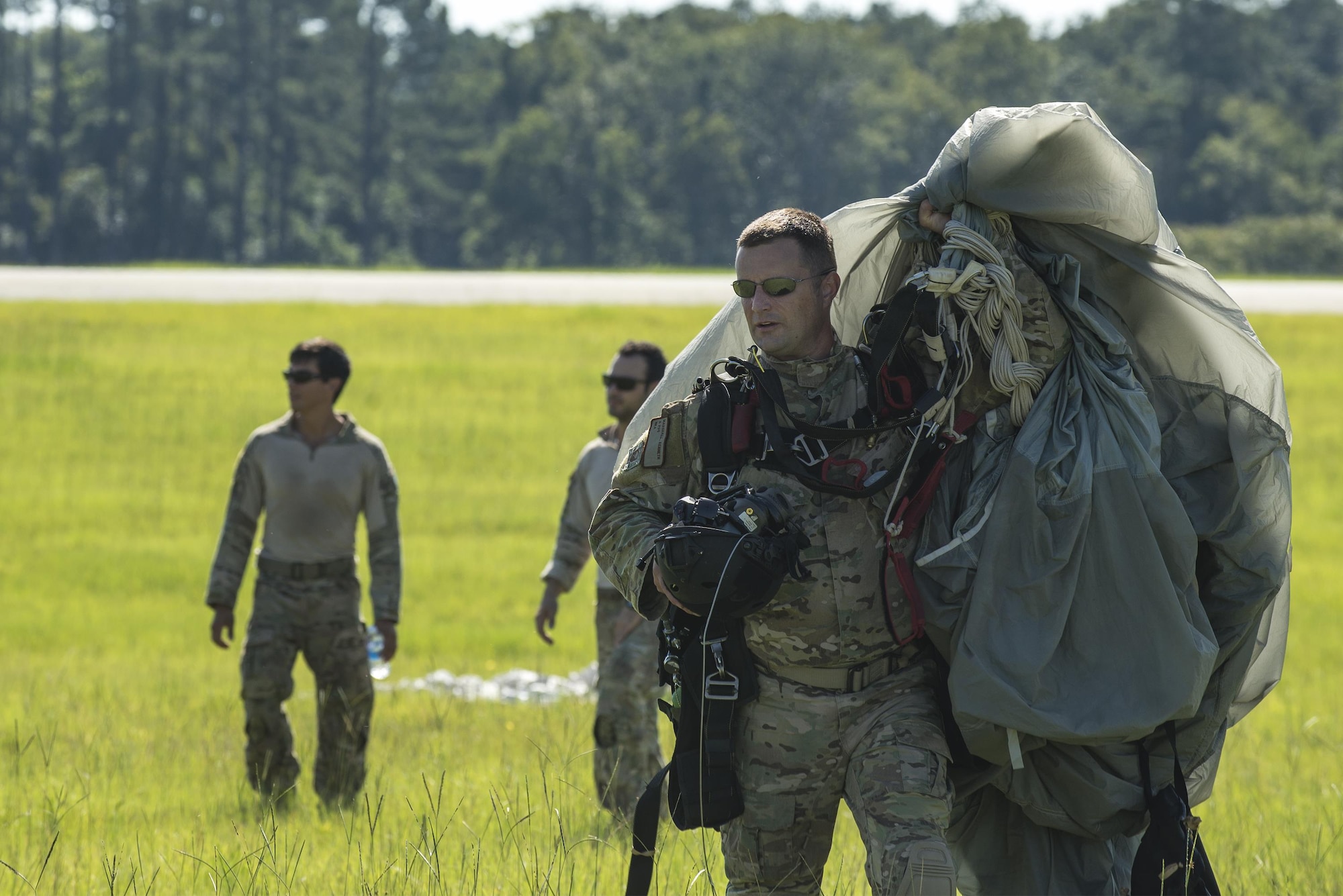 U.S. Air Force Senior Master Sgt. Kenneth Marshall, 38th Rescue Squadron pararescueman, carries his parachute after landing from a high-altitude, low-opening jump, Aug. 18, 2016, at Moody Air Force Base, Ga. The jump was conducted to re-familiarize aircrew and pararescue members with procedures for dropping from a high altitude and to ensure proficiency. (U.S. Air Force photo by Airman 1st Class Daniel Snider)
