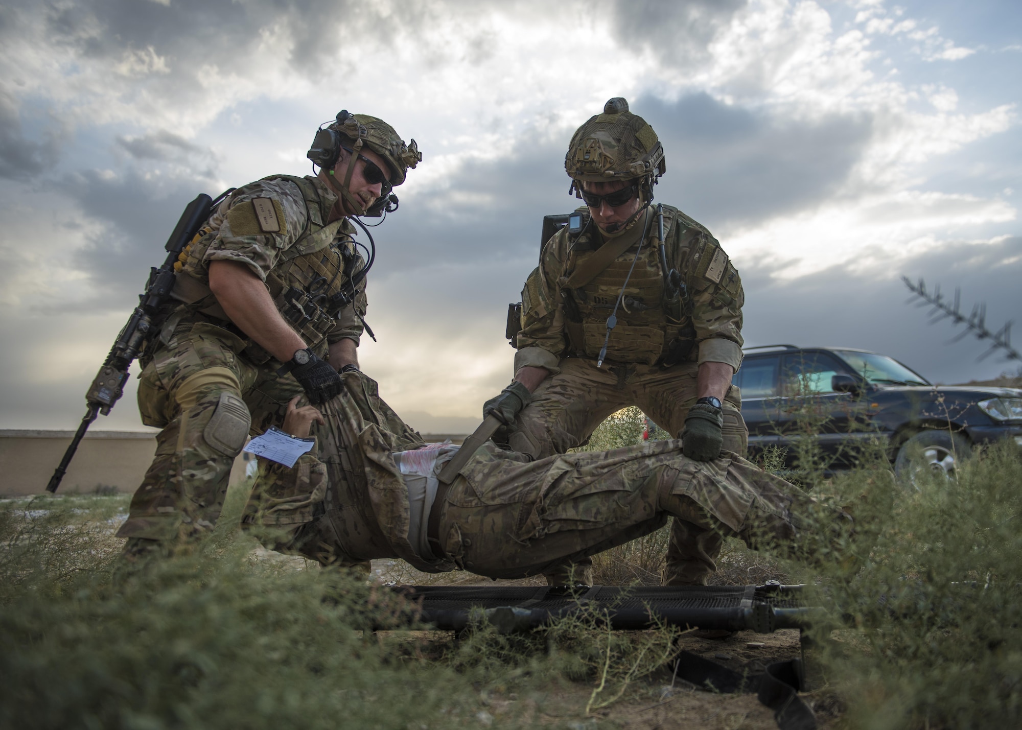 Senior Airman Kyle (left) Green and Senior Airman Ty Hatcher (right), 83rd Expeditionary Rescue Squadron pararescue specialists, lifts a patient onto a litter during a mass casualty and extraction exercise, Bagram Airfield, Afghanistan, Aug. 18, 2016. Airmen from various units acted as wounded patients with injuries that included broken limbs, deliria and head injuries. (U.S. Air Force photo by Senior Airman Justyn M. Freeman)