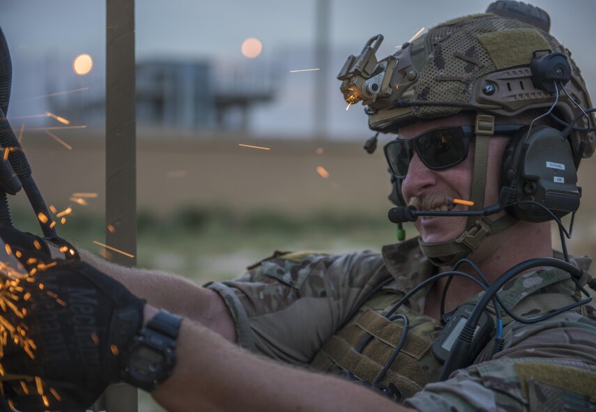 Senior Airman Kyle Green, 83rd Expeditionary Rescue Squadron pararescue specialist cuts the hinges on a mine-resistant, ambush-protected vehicle door, Bagram Airfield, Afghanistan, Aug. 18, 2016. The 83rd ERQS worked with Soldiers from the 717th Explosive Ordinance Disposal Unit to identify, remove and dispose of simulated ordnance in the area and from crashed vehicles carrying explosives, before working through scenarios such as recoving simulated wounded patients trapped in and under a MRAP, and wounds suffered from explosive devices. (U.S. Air Force photo by Senior Airman Justyn M. Freeman)