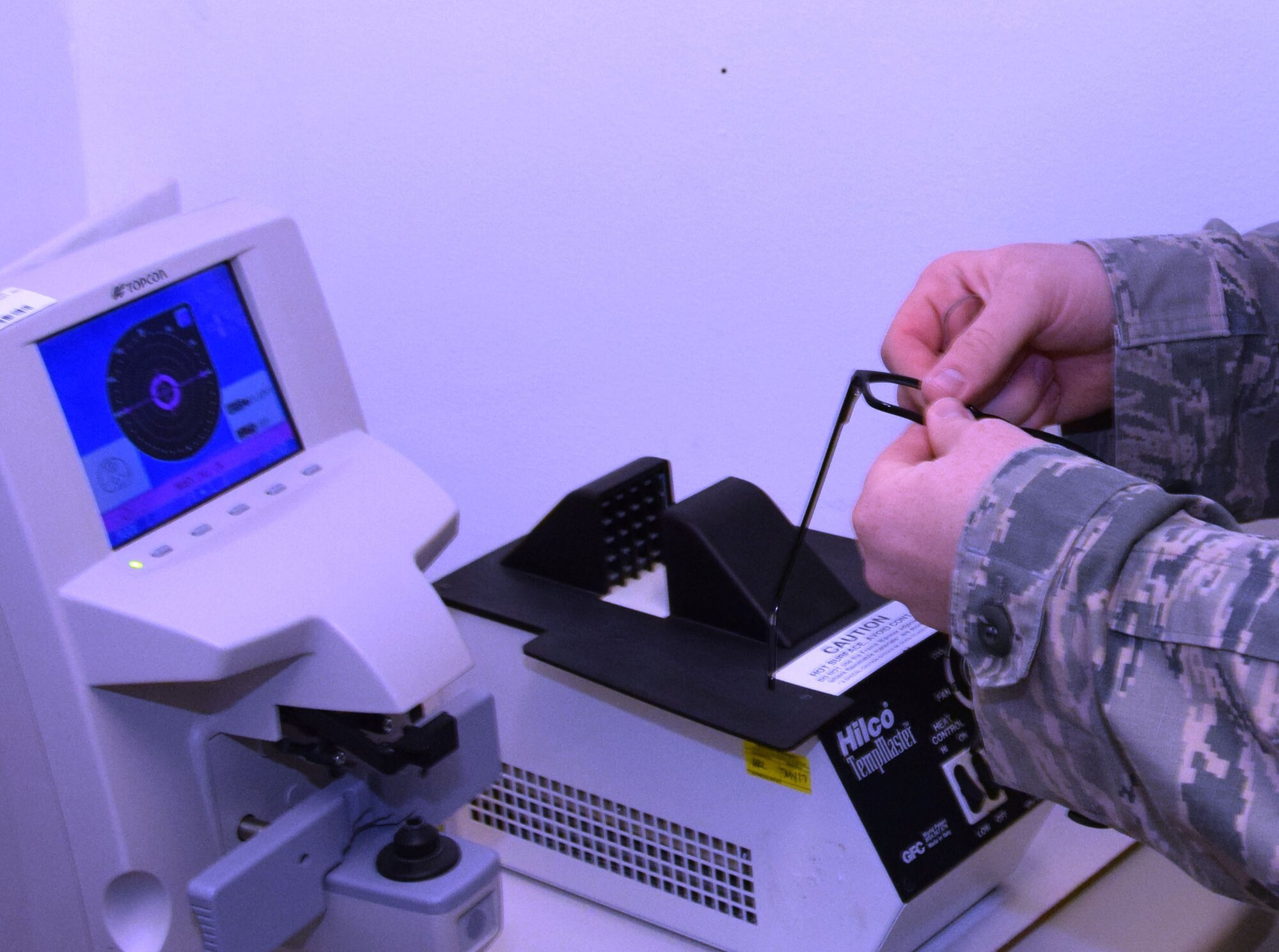 Staff Sgt. Andrew P. Heath, ophthalmic technician at the 379th Expeditionary Medical Operations Squadron, replaces a lens from a pair of government-issued glasses for a patient Aug. 2, 2016, at Al Udeid Air Base, Qatar.  The optometry clinic is stocked with both a lensometer, which determines the prescription of a pair of glasses, and a lens warmer, which warms a pair of frames to allow the technician to repair the frame here rather than sending it off-site. (U.S. Air Force photo/Technical Sgt. Carlos J. Treviño/Released)