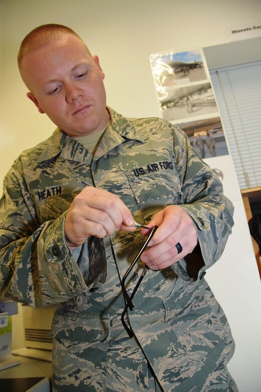 Staff Sgt. Andrew P. Heath, ophthalmic technician at the 379th Expeditionary Medical Operations Squadron, replaces and tightens a screw on a pair of government-issued glasses for a patient Aug. 2, 2016, at Al Udeid Air Base, Qatar. According to Heath, the clinic also provides other optometry services, such as updating a patient’s vision prescription and testing for glaucoma. (U.S. Air Force photo/Technical Sgt. Carlos J. Treviño/Released)