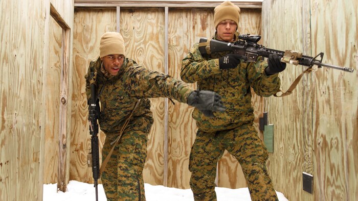 Lance Cpl. Samuel L. Posey (left), a rifleman with 3rd Platoon, Company I, 3rd Battalion, 25th Marine Regiment, 4th Marine Division, Marine Forces Reserve and Cpl. Robert D. Ray (right), a team leader with 3rd Platoon, simulate tossing a fragmentation grenade during a room clearing drill during exercise Arctic Eagle at Camp Grayling, Mich., April 7, 2016. When Posey is not wearing the uniform, he serves his community through Dance Over Anything, a dance group that performs in schools as a way to reach out to less fortunate children.