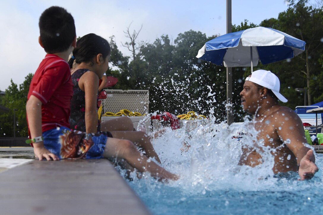Bobby Broome, swim safety instructor, gets splashed by a group of children during a swim camp event at the base pool on Joint Base Andrews, Md., Aug. 16, 2016. The event was hosted by the Zac Foundation which was established in 2008 by Brian and Karen Cohn after the loss of their 6-year-old son, Zachary Cohn, in a pool accident. The swim camp aims at reducing child pool accidents through community engagement and education. (U.S. Air Force photo by Airman 1st Class Valentina Lopez)