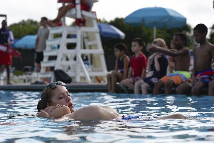 Bryn Baffer, swim safety instructor, teaches a boy how to float during swim lessons at a swim camp event at the base pool on Joint Base Andrews, Md., Aug. 16, 2016. Baffer taught the children many basic swimming skills including breathing, paddling and treading water. (U.S. Air Force photo by Airman 1st Class Valentina Lopez)