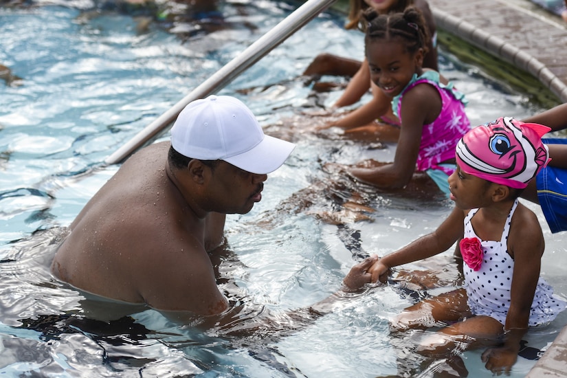 Bobby Broome, swim safety instructor, introduces himself to a youth participant in a swim camp event at the base pool on Joint Base Andrews, Md., Aug. 16, 2016. Over 50 children attended the event where they learned basic swimming skills and pool safety. (U.S. Air Force photo by Airman 1st Class Valentina Lopez)