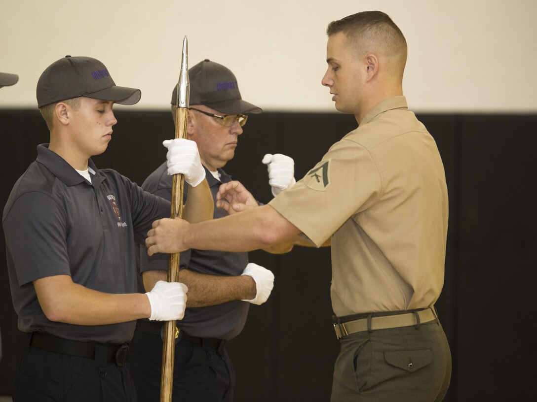 Lance Cpl. James Shea, 2nd Squad Leader, National Colors Bearer, Marine Barracks, conducts drill maneuvers with the Oakfield Fire Department Honor Guard at Marine Barracks Washington, D.C., Aug. 19, 2016. The OFD Honor Guard was formed and has been training since the fall of 2015 to provide funeral honors to local firefighters, who risk their lives in the line of duty. (Official Marine Corps photo by Lance Cpl. Robert Knapp/Released)